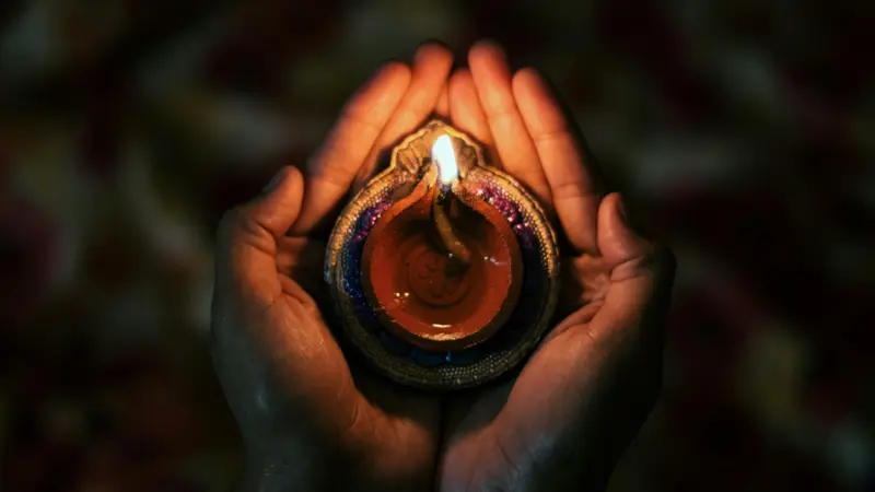Cupped hands holding a candle for ritual