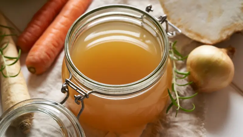photo of bone broth surrounded by vegetable ingredients