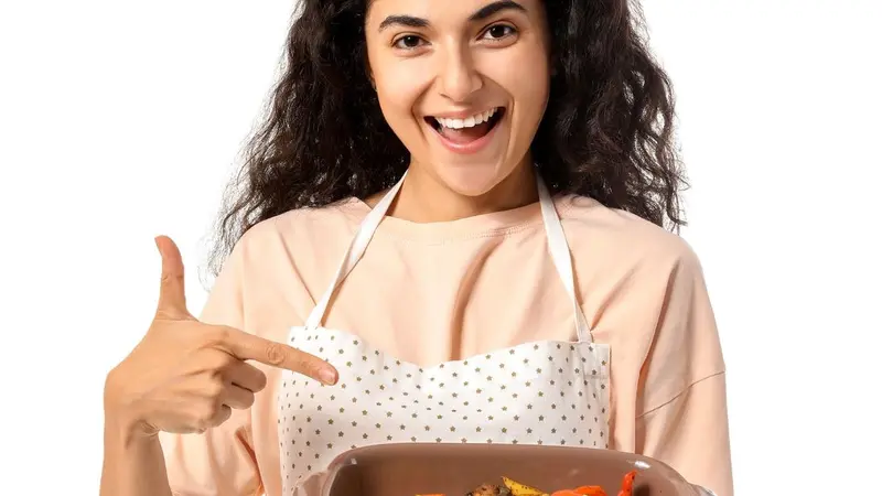 Young woman pointing at baking dish on white background