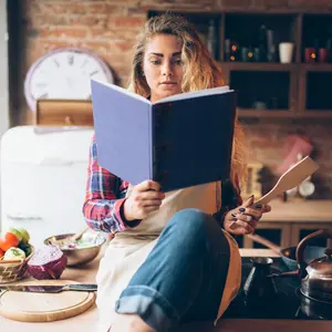 woman reading Best Life Diet book in kitchen