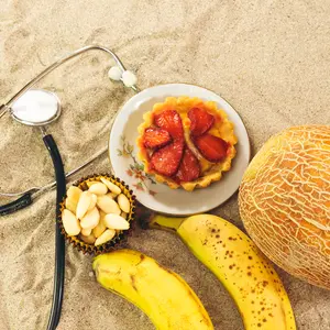 Stethoscope and fruits on sand, South Beach Diet concent