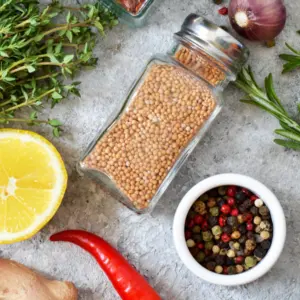 Mix of spices: rosemary, thyme, pepper, garlic, ginger, lemon on a concrete background