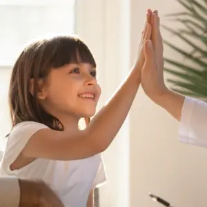 Healthy happy child girl giving high five to female caring doctor