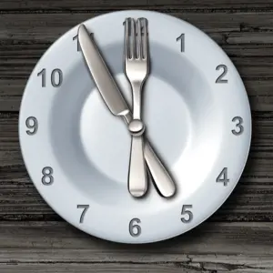 Intermittent fasting and calorie restriction promoting healthy benefits with a clock icon on a plate with knife and fork
