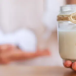 Female hand is holding jar with natural organic yogurt with bifidobacteria