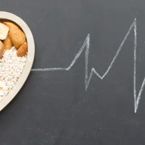 Healthy food in heart and cardiograph on blackboard
