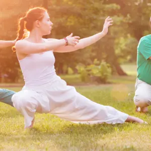 group of people practice Tai Chi Chuan in a park.