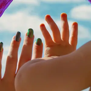 children's hands on the window pane next to a painted colored rainbow