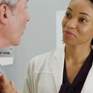 woman doctor listening to senior patient talking