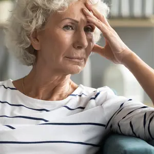 woman sitting on couch thinking