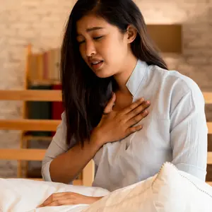  woman having difficulty breathing in bedroom