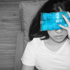 woman with cold pack on her forehead for relief headaches and migraines, black and white tone