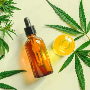 Various glass bottles with CBD oil, THC tincture and hemp leaves on a marble background