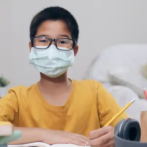 Boy wearing face masks online study homeshcooling at home.