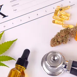 Assorted cannabis products, pills and cbd oil over medical prescription sheet - medical marijuana concept