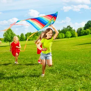 Four little kids running in the park with kite happy and smiling