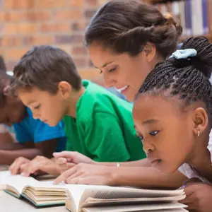 pupils and teacher lying on floor in library at the elementary school