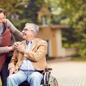 man in wheelchair with happy caregiver