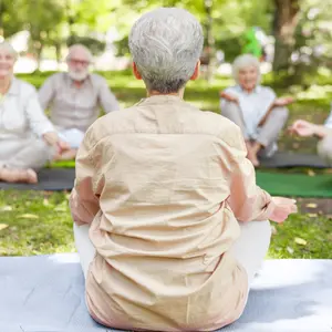 instructor leading meditation for group of elderly people