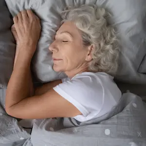 woman sleeping on soft pillow under blanket, enjoying sweet dreams at night