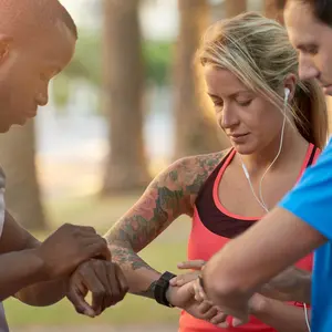 group of friends looking at their fitness trackers smartwatch before their run jog workout group of friends looking at their fitness trackers smartwatch before their run jog workout