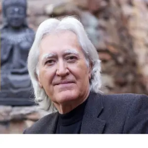 Larry Dossey, MD with prayer statue behind him