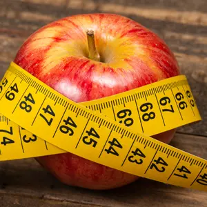 Apple with measuring tape, symbolizing overweight and metabolic syndrome