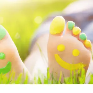 Child lying on green grass. Kid having fun outdoors in park