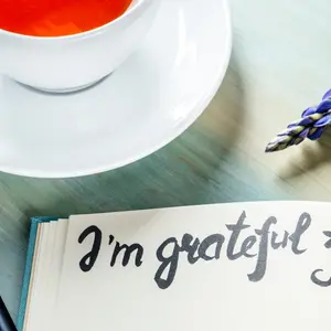 Gratitude journal with a flower and a cup of tea, with the handwritten phrase I am grateful for