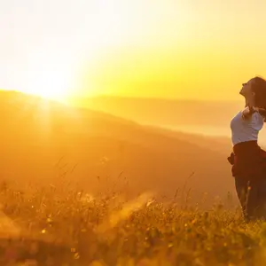 Happy woman on the sunset in nature in summer with open hands Happy woman on the sunset in nature in summer with open hands