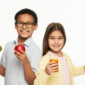 Multi-ethnic group of children with healthy vegetables, fruits, and carrot juice
