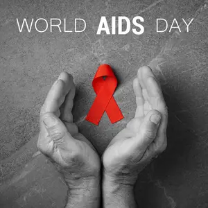 Red ribbon in hands on gray background, World AIDS Day, symbol of fight against HIV and AIDS