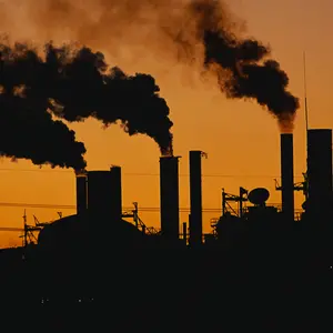 Factory at sunset. These are smokestacks contributing to the pollution in the air.