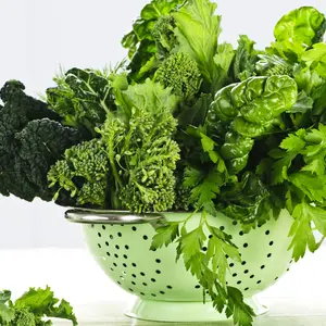 Dark green leafy fresh vegetables in metal colander