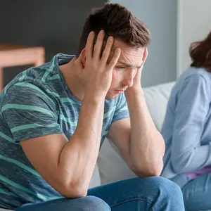 Happy mother with her baby and young father suffering from postnatal depression at home