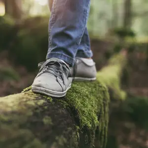 Woman walking on a log in the forest and balancing