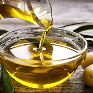 Bottle pouring virgin olive oil in a bowl close up