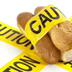 Dietary warning for gluten-related disorders (Slices of fresh French bread wrapped in yellow caution tape)