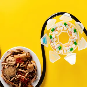 Chinese herb medicine and pills wrapped with a stethoscope on yellow background