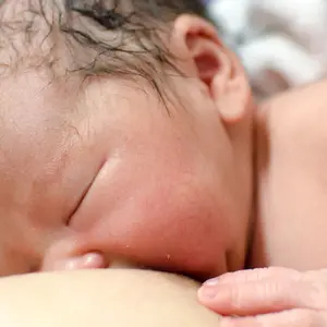 Newborn baby breast feeding.