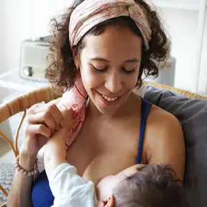 Young mixed race mother enjoying intimate moment with her baby son while breastfeeding him
