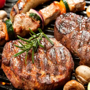 Assorted delicious grilled meat with vegetable over the coals on a barbecue