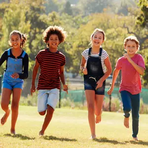 Six pre-teen friends running in a park, front view, close up