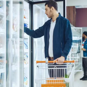 At the Supermarket, Men Browse for Products in the Frozen Goods Section