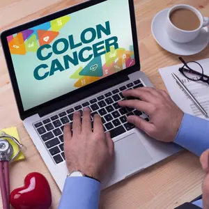 Doctor working on a laptop and COLON CANCER on his screen