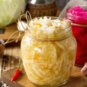 Homemade Sauerkraut with Carrot and Salad Cabbage with Beetroot on a wooden table.