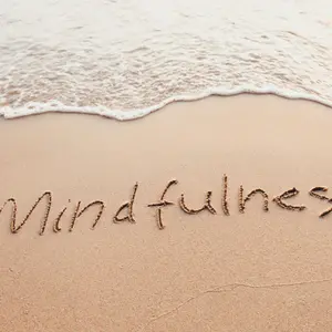 Mindfulness concept, text written on the sand of beach Mindfulness concept, text written on the sand of beach
