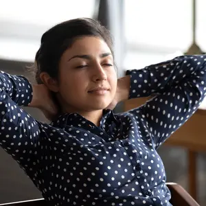 Calm relaxed Indian lady practicing breath work at home office