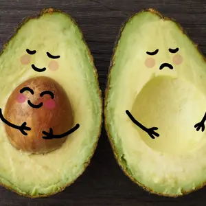 An avocado parent and child in embrace beside another avocado who is sad that is it without a child or baby