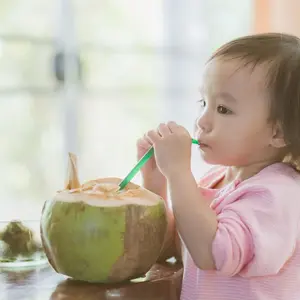 Child drinking from a coconut